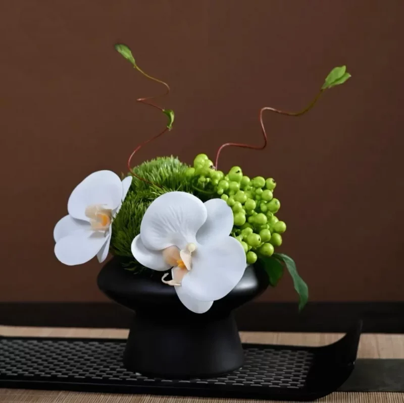 Arrangement “Parfum Envolé” – Orchidée blanche et baies vertes